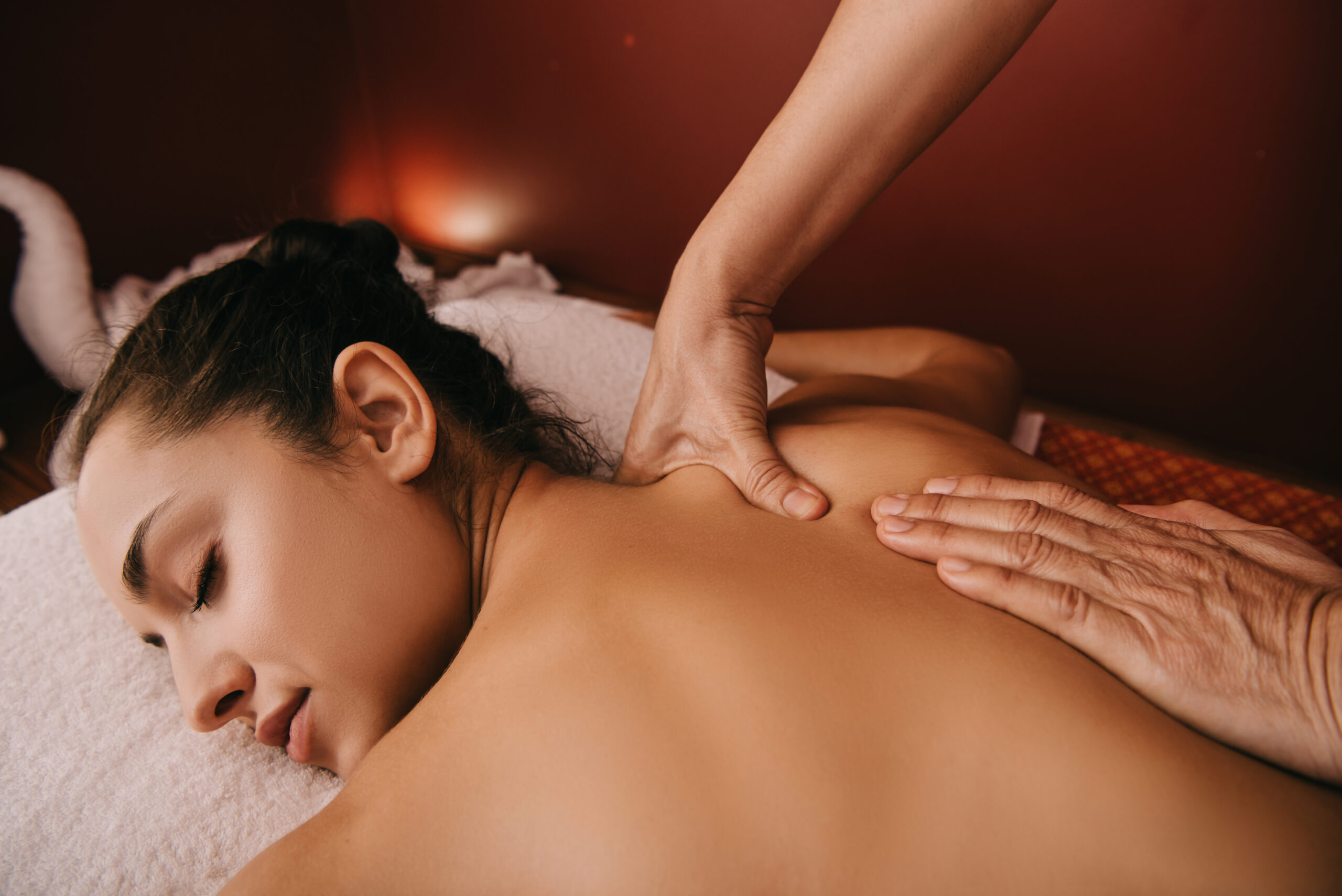 cropped view of masseur doing back massage to woman on massage mat